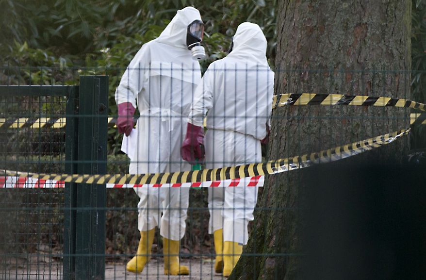 Two men in white hazmat suits stand at the entrance of the Grand Mosque of Brussels on Thursday, Nov 26, 2015. Emergency personnel responded at the mosque after a suspicious package was found. (AP Photo/Virginia Mayo)