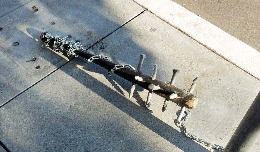 This Thursday, Nov. 26, 2015, photo provided by Pablo Diaz-Gutierrez shows a baseball bat with large lag screws embedded in it, chained to a pole in the Mission district San Francisco. Police are asking for help in finding who is chaining up these spiked bats to poles throughout the city. (Pablo Diaz-Gutierrez via AP)