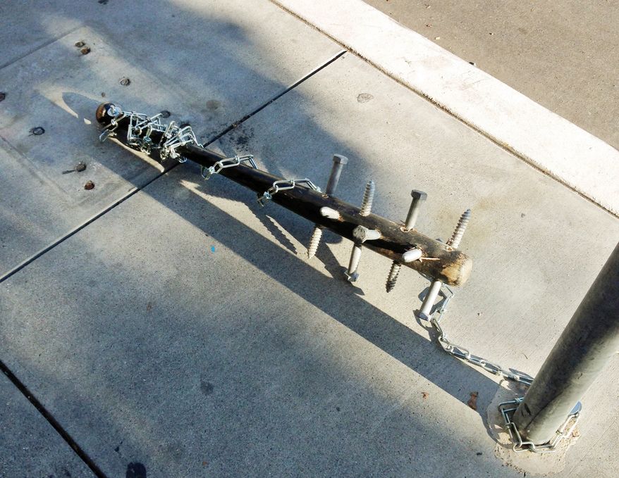 This Thursday, Nov. 26, 2015, photo provided by Pablo Diaz-Gutierrez shows a baseball bat with large lag screws embedded in it, chained to a pole in the Mission district San Francisco. Police are asking for help in finding who is chaining up these spiked bats to poles throughout the city. (Pablo Diaz-Gutierrez via AP)