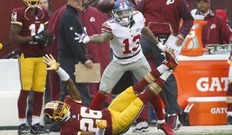 New York Giants wide receiver Odell Beckham (13) and Washington Redskins cornerback Bashaud Breeland (26) both reach for an overthrown Eli Manning pass during the first half of an NFL football game in Landover, Md., Sunday, Nov. 29, 2015. (AP Photo/Alex Brandon)
