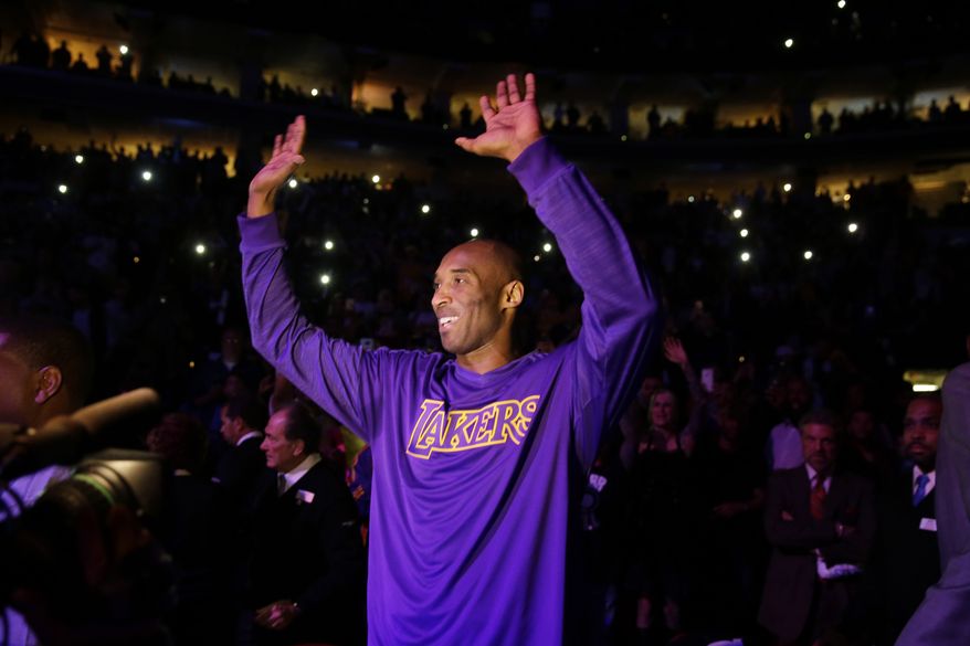 Los Angeles Lakers' Kobe Bryant acknowledges the audience ahead of a basketball game against the Philadelphia 76ers Tuesday, Dec. 1, 2015, in Philadelphia. (AP Photo/Matt Rourke)