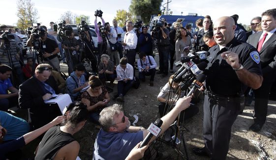 San Bernardino Police Chief Jarrod Burguan, right, talks to the media near the the site of a mass shooting on  Wednesday, Dec. 2, 2015, in San Bernardino, Calif. One or more gunmen opened fire Wednesday at a Southern California social services center, shooting several people as others locked themselves in their offices, desperately waiting to be rescued by police, witnesses and authorities said. Authorities said the shooting rampage killed multiple people and wounded others. (AP Photo/Chris Carlson)