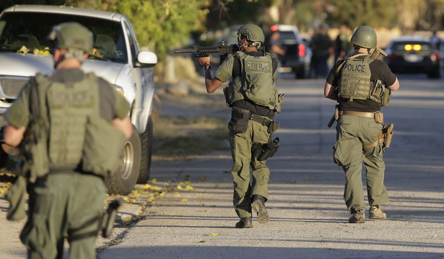 Law enforcement searches for a suspect in a mass shooting at a social services center Wednesday in San Bernardino, Calif. (Associated Press)