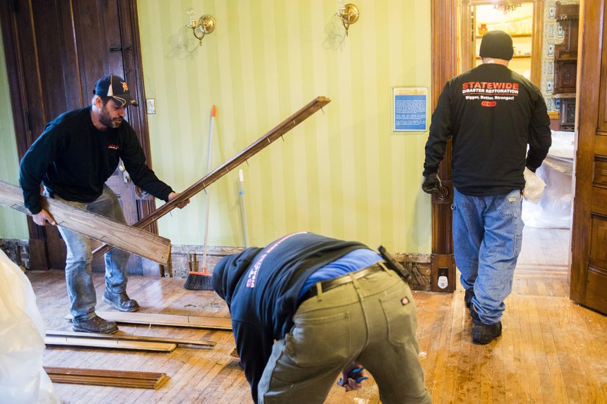 A cleaning crew works to restore the Whaley Historic House Museum on Tuesday, Dec. 1, 2015, near downtown Flint, the day after a fire broke out in the third floor and on the roof, leaving heavy damage throughout the building. Museum president Thomas Henthorn says most of the museum's collections were on the other opposite side of the fire. But he noted that any damage to the house is significant because the house is an artifact. (Jake May/The Flint Journal-MLive.com via AP) LOCAL TELEVISION OUT; LOCAL INTERNET OUT; MANDATORY CREDIT (REV-SHARE) (ONLN OUT; IONLN OUT - MBI)