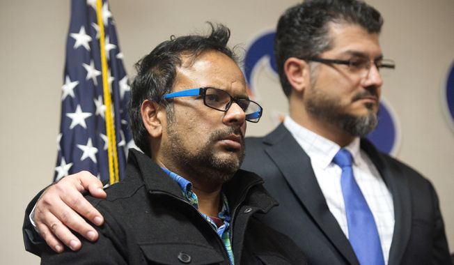 Farhan Khan, left, brother-in-law of one of the suspects involved in a shooting in San Bernardino, Calif., is held by Hussam Ayloush, executive director of Council on American-Islamic Relations, during a news conference at the Greater Los Angeles Area office of the Council on American-Islamic Relations, in Anaheim, Calif. Multiple attackers opened fire on a banquet at a social services center for the disabled in San Bernardino on Wednesday, killing multiple people and sending police on a manhunt for suspects. (Matt Masin/The Orange County Register via AP) MAGS OUT; LOS ANGELES TIMES OUT; MANDATORY CREDIT