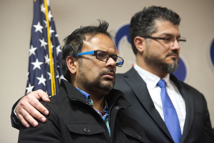 Farhan Khan, left, brother-in-law of one of the suspects involved in a shooting in San Bernardino, Calif., is held by Hussam Ayloush, executive director of Council on American-Islamic Relations, during a news conference at the Greater Los Angeles Area office of the Council on American-Islamic Relations, in Anaheim, Calif. Multiple attackers opened fire on a banquet at a social services center for the disabled in San Bernardino on Wednesday, killing multiple people and sending police on a manhunt for suspects. (Matt Masin/The Orange County Register via AP) MAGS OUT; LOS ANGELES TIMES OUT; MANDATORY CREDIT
