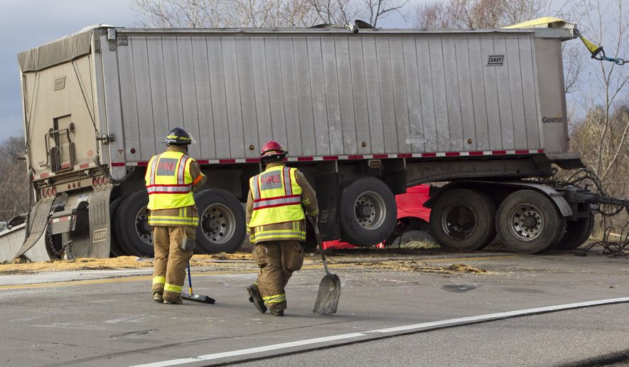 Members of the Walker Fire Department respond to the scene after a semi truck rolled over at the southbound U.S. 131 entrance to eastbound I-96, Thursday, Dec. 3, 2015. The truck spilled corn. (Cory Morse/The Grand Rapids Press/MLive.com via AP)