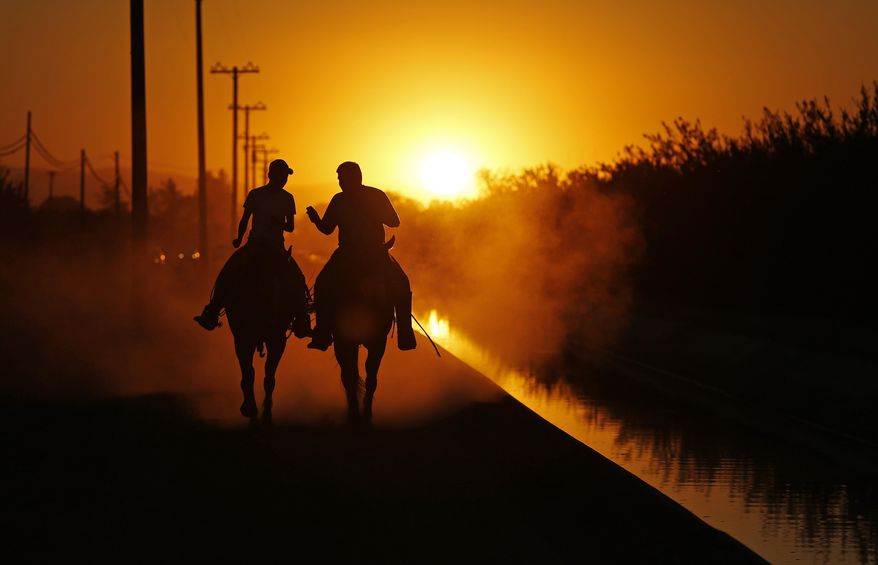 ADVANCE FOR USE USE TUESDAY, DEC. 8, 2015 AT 12:01 A.M. EST AND THEREAFTER - In this Sept. 17, 2015 photo, two men ride on horseback along an irrigation canal in agricultural land near Modesto, Calif. Uranium, the stuff of nuclear fuel for power plants and atom bombs, increasingly is showing up in drinking-water systems in major farming regions of the U.S. West, as an unexpected by-product of irrigation and, increasingly, of drought and the overpumping of natural underground water reserves. (AP Photo/John Locher)