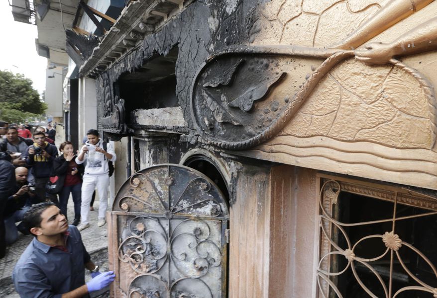 An Egyptian forensic member checks the entrance of a nightclub which was attacked in Cairo, Egypt, Friday, Dec. 4, 2015. More than a dozen were killed and wounded, Egypt's state-run news agency reported. MENA quoted an unnamed security official as saying three men on a motorcycle threw Molotov cocktails into the club in the Agouza district and then fled. (AP Photo/Amr Nabil)