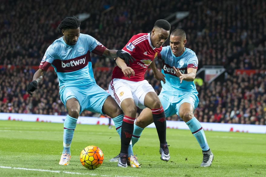 Manchester United&#39;s Anthony Martial, centre, fights for the ball against West Ham United&#39;s Alexandre Song, left, and Winston Reid during the English Premier League soccer match between Manchester United and West Ham United at Old Trafford Stadium, Manchester, England, Saturday, Dec. 5, 2015. (AP Photo/Jon Super)