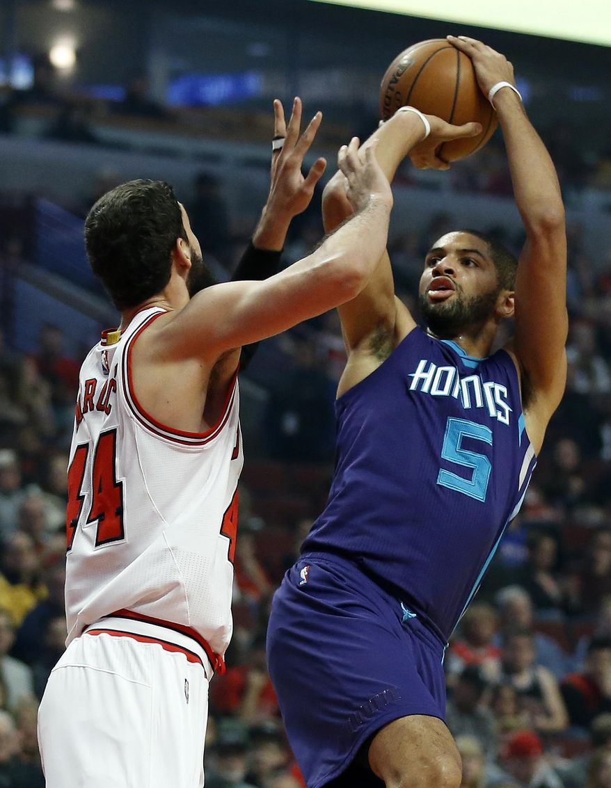 Charlotte Hornets guard Nicolas Batum (5) shoots over Chicago Bulls forward Nikola Mirotic (44) during the first half of an NBA basketball game in Chicago, Saturday, Dec. 5, 2015. (AP Photo/Andrew A. Nelles)