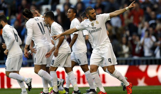 Real Madrid&#x27;s Karim Benzema, right, celebrates with teammates after scoring the opening goal against Getafe during the Spanish La Liga soccer match between Real Madrid and Getafe at the Santiago Bernabeu stadium in Madrid, Saturday, Dec. 5, 2015. (AP Photo/Francisco Seco)