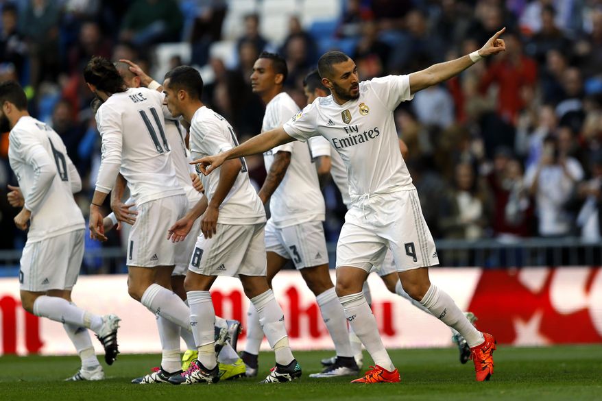 Real Madrid's Karim Benzema, right, celebrates with teammates after scoring the opening goal against Getafe during the Spanish La Liga soccer match between Real Madrid and Getafe at the Santiago Bernabeu stadium in Madrid, Saturday, Dec. 5, 2015. (AP Photo/Francisco Seco)
