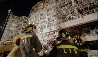 Fire personnel gather at the base of the Alfred P. Murrah Federal Building in downtown Oklahoma City on April 20, 1995, the day after the bombing. (Associated Press)