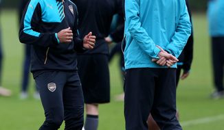 Arsenal manager Arsene Wenger, right, speaks to Theo Walcott during a training session at London Colney, London Tuesday Dec. 8, 2015.  (Simon Cooper/PA via AP) UNITED KINGDOM OUT