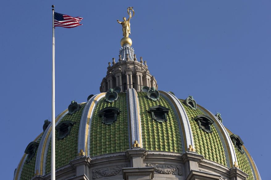 The United States flag waves in the wind at the Pennsylvania Capitol building Tuesday, Dec. 8, 2015, in Harrisburg, Pa. The Pennsylvania House and Senate moved toward a showdown over competing spending and tax plans Monday, with the fate of suffering counties, schools and social services agencies hanging in the balance of a 5-month budget stalemate. (AP Photo/Matt Rourke)
