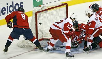 Washington Capitals left wing Alex Ovechkin (8) scores the tying goal past Detroit Red Wings goalie Jimmy Howard (35) with Red Wings defenseman Jonathan Ericsson (52) nearby in the third period of an NHL hockey game, Tuesday, Dec. 8, 2015, in Washington. The Capitals won 3-2 in a shootout. (AP Photo/Alex Brandon)