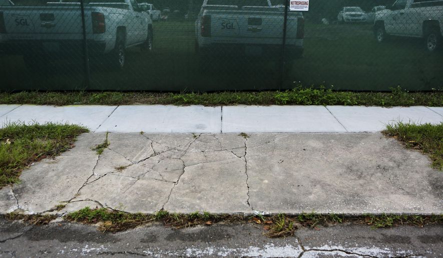 ADVANCE FOR SUNDAY DEC. 12 AND THEREAFTRER - The driveway to the Galarza family home on Dolores Drive home in Altamonte Springs nows leads to a locked fence used to house contruction equipment on Dec. 3, 2015. The family had to move out of their home in 2009. The Florida Department of Transportation in 2009 used the power of eminent domain to seize 39 homes south of State Road 436 in Altamonte Springs for a project that never happened. (Jacob Langston/Orlando Sentinel via AP)