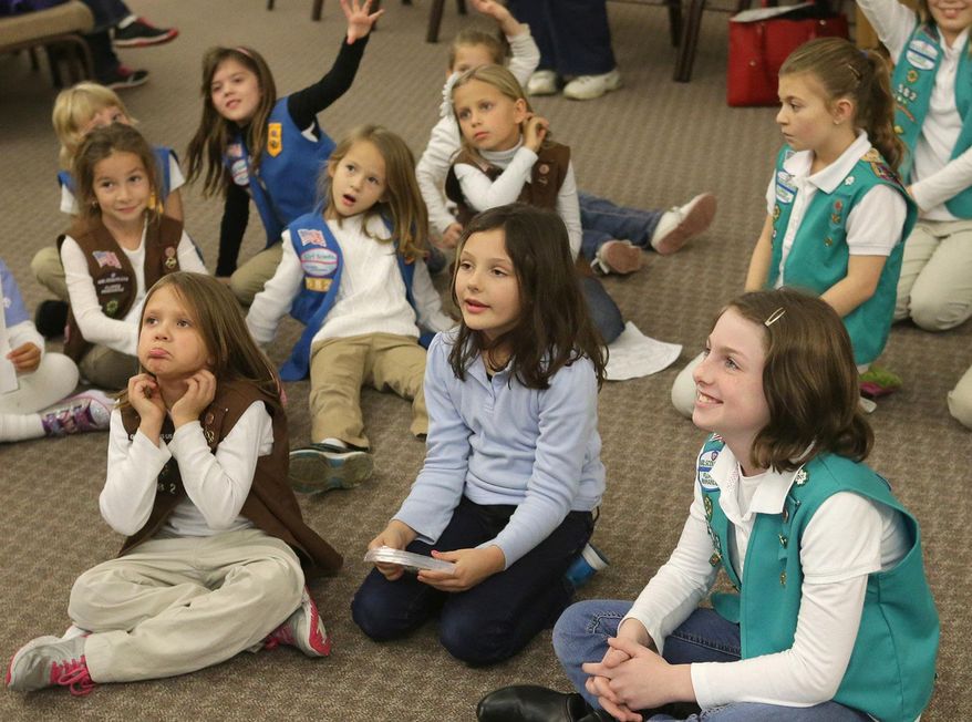 FILE - In this Thursday, Jan. 8, 2015 file photo, girls listen during the Girl Scout Troop 582's cookie training session at Beach Vineyard Church in Panama City Beach, Fla. As the Girl Scouts' membership continues a sharp decline, its leaders are betting on technology to reverse the trend, including a major expansion of its year-old program enabling Girl Scout cookies to be sold via mobile apps and the girls’ personalized websites. The Digital Cookie upgrade, announced on Tuesday, Dec. 8, 2015 comes amid persisting challenges for the 103-year-old organization. (Heather Leiphart/The News Herald via AP)