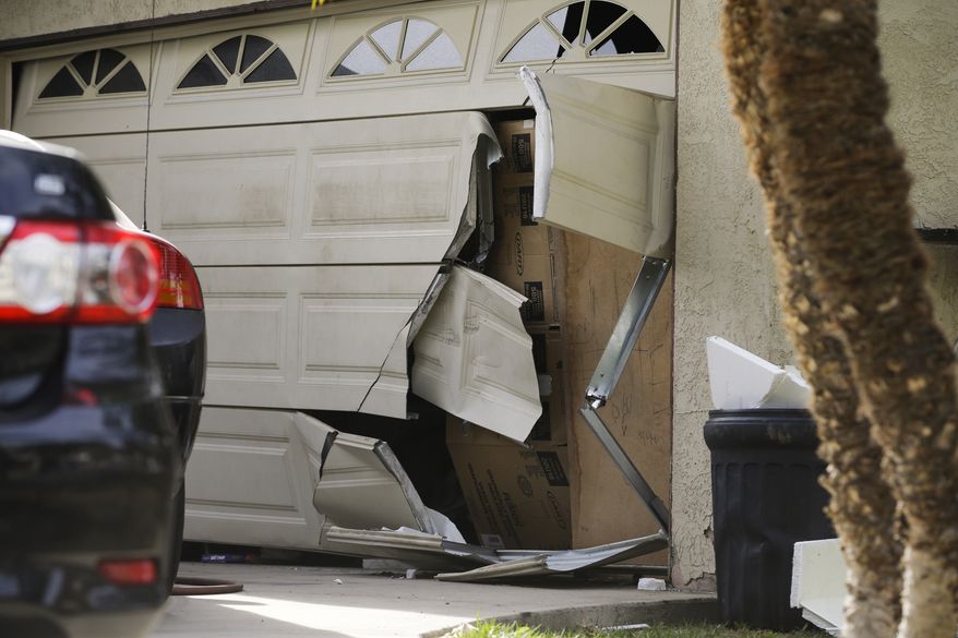 A garage door of Enrique Marquez&#39;s home is seen broken in a recent FBI raid, Wednesday, Dec. 9, 2015, in Riverside, Calif. Authorities have said Enrique Marquez, an old friend of San Bernardino attacker Syed Farook, purchased two assault rifles used in last week&#39;s fatal shooting that killed 14 people. (AP Photo/Jae C. Hong)

