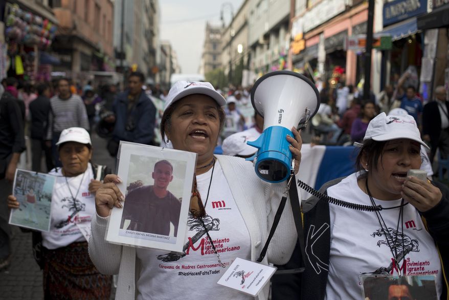 Central American women hold photographs of their disappeared family members as they march in Mexico City, Wednesday, Dec. 9, 2015. The caravan of women is traveling through Mexico to search for their missing relatives who left for a better life in the U.S. but disappeared. (AP Photo/Eduardo Verdugo)