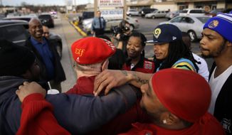&quot;Secret Santa,&quot; in red &quot;Elf&quot; hat, gets hugs of thanks after handing out several $100 bills along West Florissant Avenue, Wednesday, Dec. 9, 2015, in Ferguson, Missouri. &quot;Secret Santa&quot; is an anonymous Kansas City-area man who hands out cash to the needy during the holiday season and decided the Ferguson area is one place he wanted to stop this year. (AP Photo/Jeff Roberson)