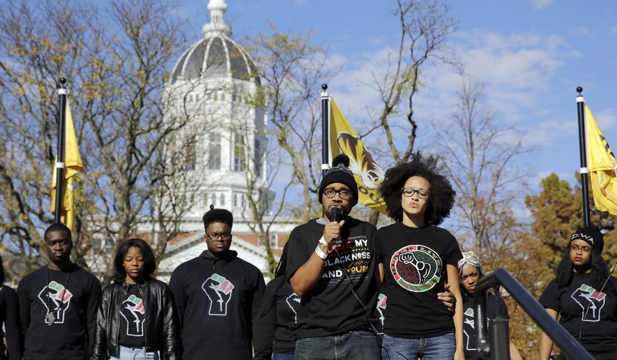 In this Nov. 9, 2015 photo, Jonathan Butler, center, addresses a crowd in Columbia following the resignation of University of Missouri System President Tim Wolfe after days of protests over concerns about the administration's handling of racial issues. (AP Photo/Jeff Roberson/File)