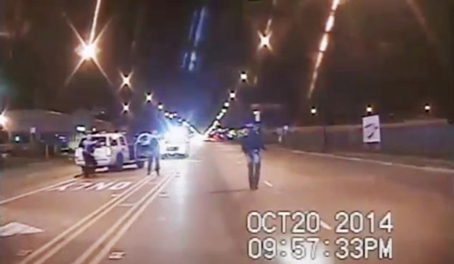 In this Oct. 20, 2014, frame from dash-cam video provided by the Chicago Police Department, Laquan McDonald, right, walks down the street moments before being shot by Officer Jason Van Dyke in Chicago. (Chicago Police Department via AP, File)