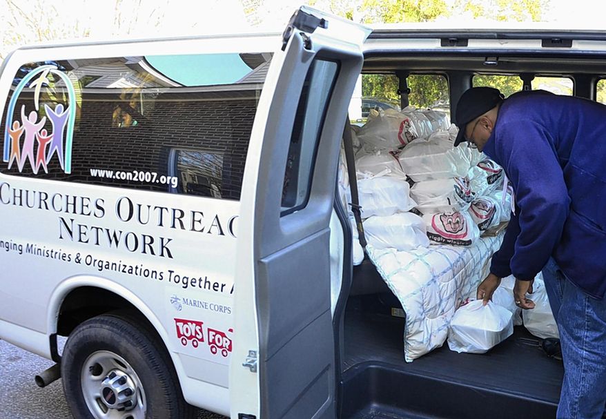 ADVANCE FOR THE WEEKEND OF DEC. 12-13 AND THEREAFTER - In a Saturday, Nov. 21, 2015 photo, Churches Outreach Network's van is filling up to deliver plates from the JOY Soup Kitchen's annual Thanksgiving dinner in Greenville, N.C. (Bayardo Caceres-Rossel/The Daily Reflector)