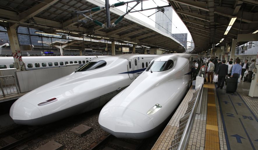 FILE - In this Sept. 24, 2014 filephoto, passengers get on the Shinkansen high-speed train at Tokyo station in Tokyo. Indian Prime Minister Narendra Modi hopes the visit this weekend by Shinzo Abe, starting Friday, Dec. 11, 2015, will be a major step in transforming India into an economic powerhouse with Japan's help in building bullet trains, "smart cities" and accessing nuclear technology. India and Japan are set to sign a $15 billion agreement for a high-speed train linking the Indian financial hub of Mumbai with Ahmadabad, the commercial capital of Modi's home state, Gujarat. The train would cut travel time on the 505 kilometer (315 mile) route from eight hours to two. (AP Photo/Shizuo Kambayashi, File)