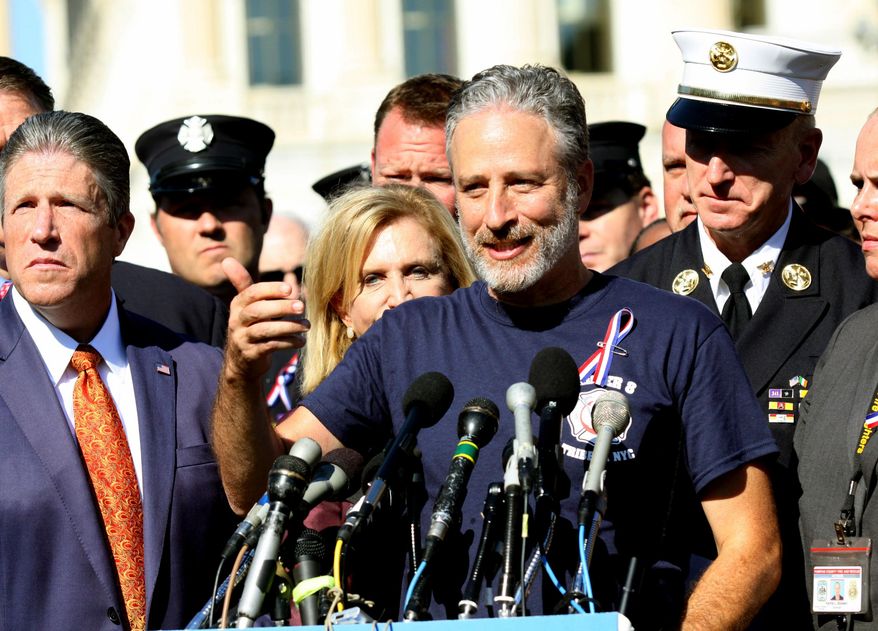 FILE - In this Sept. 16, 2015 file photo, Comedian Jon Stewart stands with New York City first responders during a rally on Capitol Hill in Washington. Steward called for the extension of the the Zadroga Heath & Compensation Act that provides health care and compensation to 9/11 first responders and victims will come to an end if not renewed by Congress. Stewart appeared with Stephen Colbert on the CBS "Late Show," Thursday Dec. 10, to push Congress to approve more funding to treat people sickened by working in the rubble of the World Trade Center following the Sept. 11 attacks. (AP Photo/Lauren Victoria Burke, File)