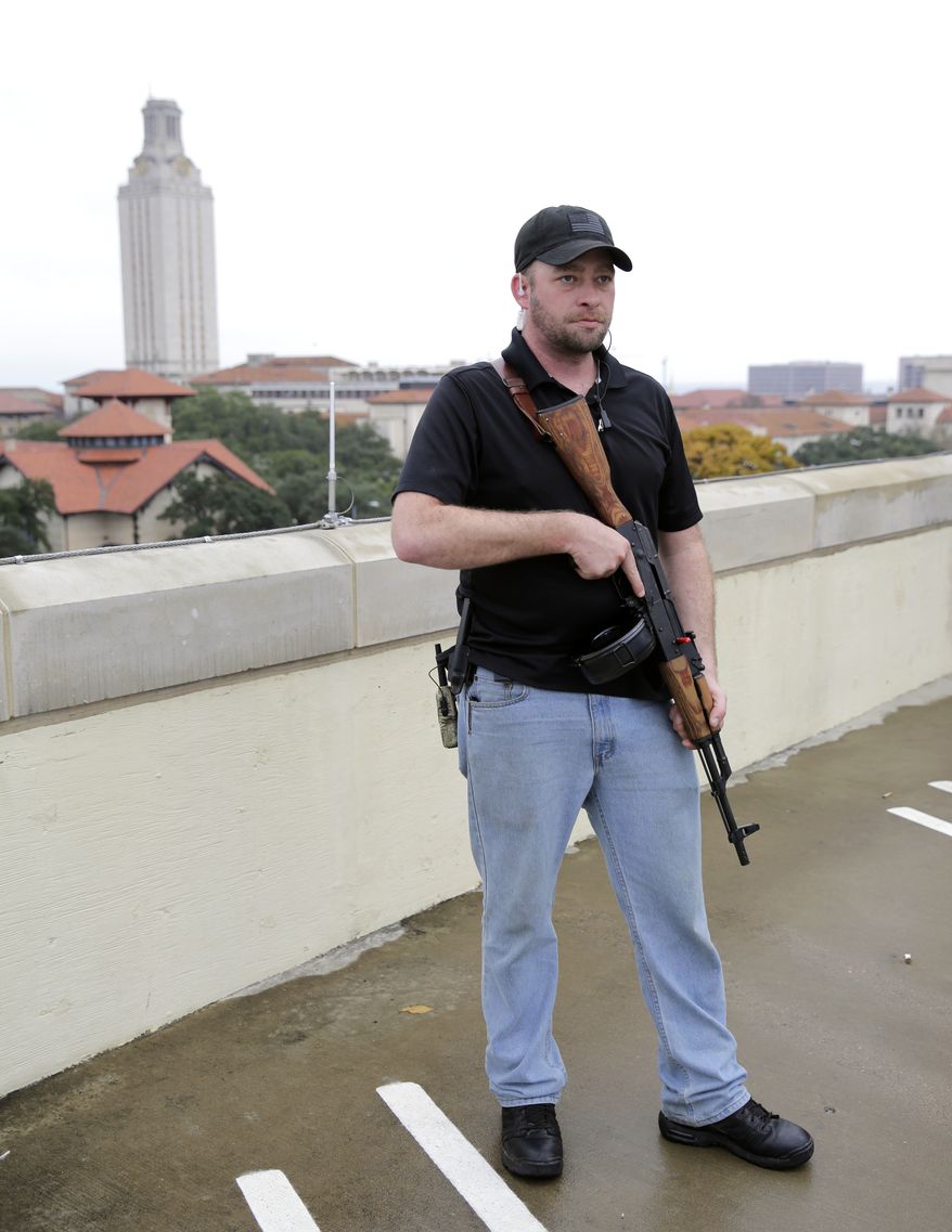 Gun rights activist Michael Short holds a gun as he prepares for a march near the University of Texas, Saturday, Dec. 12, 2015, in Austin, Texas. The group is planning a mock mass shooting near the campus. (AP Photo/Eric Gay)