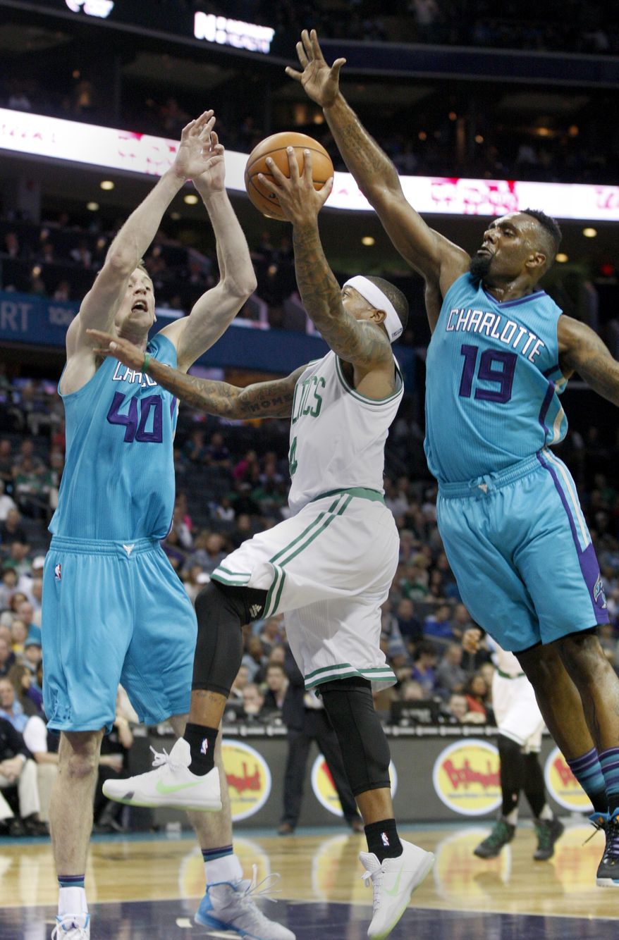 Boston Celtics guard Isaiah Thomas, center, drives to the basket against through the double team of Charlotte Hornets forwards Cody Zeller, left, and P.J. Hairston in the first half of an NBA basketball game Saturday, Dec. 12, 2015 in Charlotte, N.C. (AP Photo/Nell Redmond)