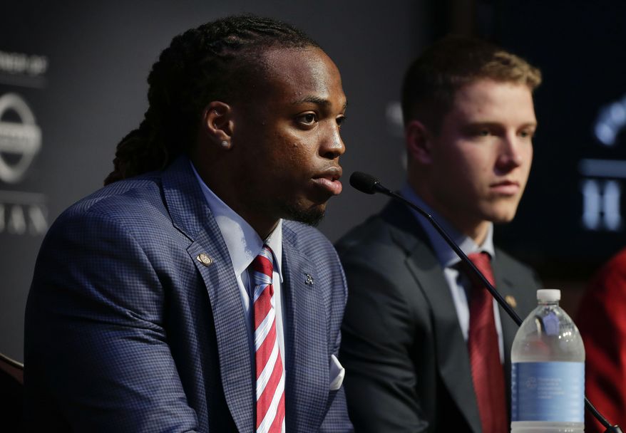Alabama's Derrick Henry, left, answers questions for the media as Stanford's Christian McCaffrey looks on before the start of the Heisman Trophy award presentation show, Saturday, Dec. 12, 2015, in New York. (AP Photo/Julie Jacobson)