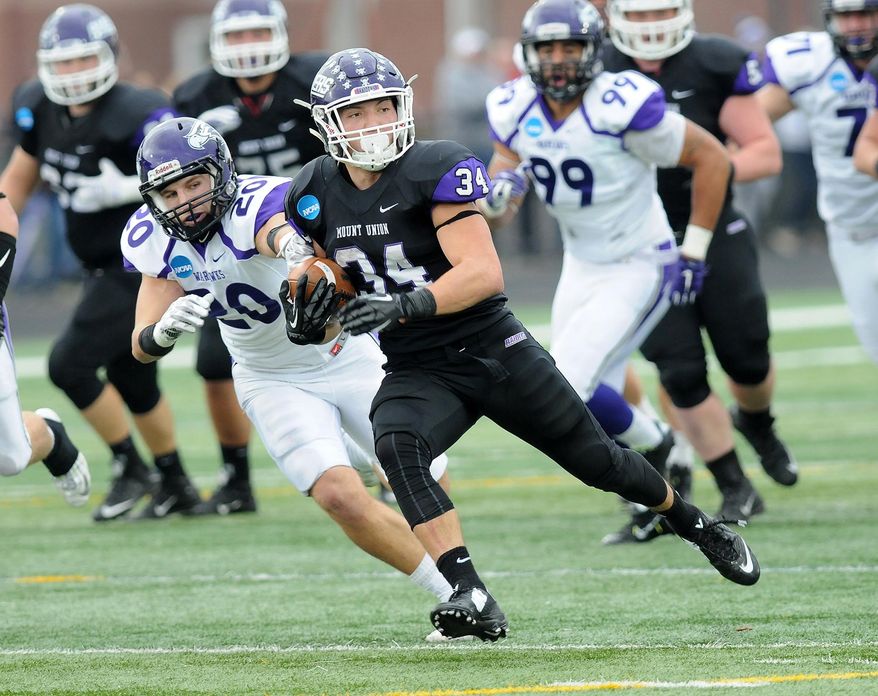 Mount Union Logan Nemeth (34) carries on a long run from scrimmage as Wisconsin-Whitewater's Shawn Shilcox pursues in the third quarter of the semifinals of an NCAA Division III college football game, Saturday, Dec. 12, 2015, in Alliance, Ohio. (Ed Hall Jr./The Review via AP) MANDATORY CREDIT