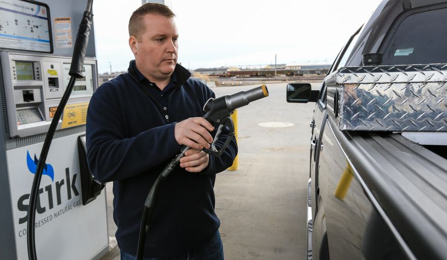 Mike Hoelsher fuels a pickup truck with compressed natural gas in Lincoln, Neb., Friday, Dec. 11, 2015. Cars and trucks that run on this fuel could be able to cross Nebraska and travel the state much more extensively with a new fueling station that’s set for construction next year. The expected station in North Platte, Neb., would close a major gap on Interstate 80 and allow more vehicles to make the trip from Omaha and Lincoln to Cheyenne and Denver. (AP Photo/Nati Harnik)