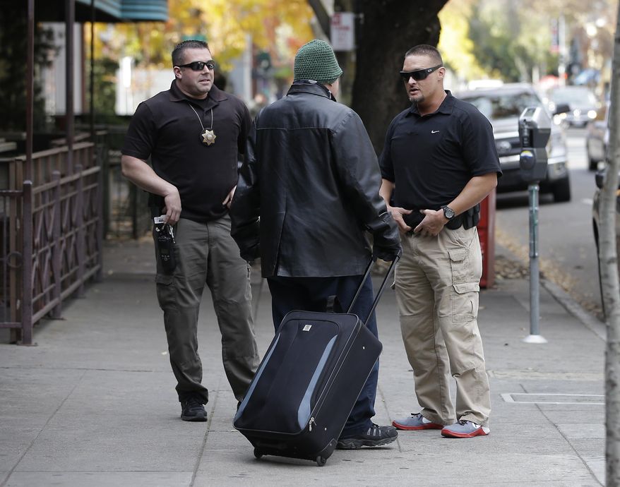 In this photo taken Tuesday, Dec. 1, 2015, parole agents Andrew Correa, left, and Clint Cooley, right, talk with a sex-offender parolee they located by tracking the global positioning device he wears, in Sacramento, Calif. Parole agents use a global positioning devices to locate parolees to make unannounced stops. State corrections officials recently completed a review how many sex offenders must comply with voter-approved residency restrictions based on a state supreme court decision. The corrections department announced a dramatic reduction in the number of offenders barred from living near schools and parks.(AP Photo/Rich Pedroncelli)
