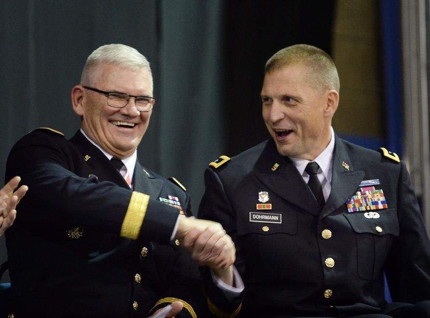 North Dakota National Guard retiring Adjutant Gen. David Sprynczynatyk, left, shares a laugh with incoming Adjutant Gen. Alan Dohrmann during the change of command ceremony in Bismarck, Sunday, Dec. 13, 2015. Sprynczynatyk is retiring after 43 years of military service. He has been the Adjutant General of North Dakota since 2006. (Will Kincaid/The Bismarck Tribune via AP) MANDATORY CREDIT