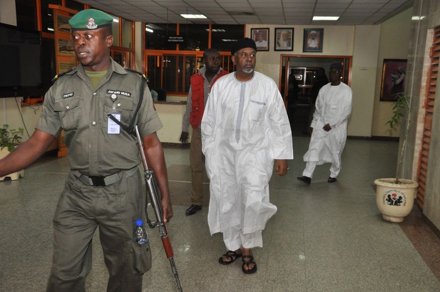 Nigeria's former national security adviser Sambo Dasuki , centre, arrives for a hearing to face charges of possessing weapons illegally, at the Federal High Court in Abuja, Nigeria, Monday, Dec. 14, 2015. Nigeria’s former national security adviser says $47 million was withdrawn in cash from the Central Bank on the order of former President Goodluck Jonathan and was used to pay delegates at a party presidential nomination conference. Retired Col. Sambo Dasuki submitted the written statement before he was charged Monday at the Federal High Court with 19 counts of money-laundering and criminal breach of trust connected to the disappearance of $2.1 billion meant to buy arms to fight Boko Haram. (AP Photo/Olamikan Gbemiga)