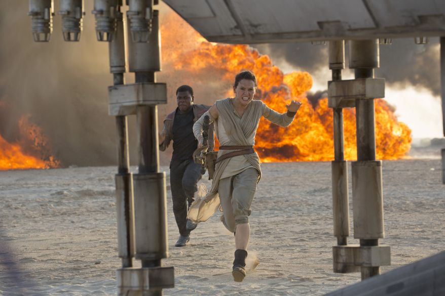 This photo provided by Disney/Lucasfilm shows Daisy Ridley, right, as Rey, and John Boyega as Finn, in a scene from the film, "Star Wars: The Force Awakens," directed by J.J. Abrams. Early screenings of the film begin Thursday night, Dec. 17, 2015. (David James/Disney/Lucasfilm via AP)