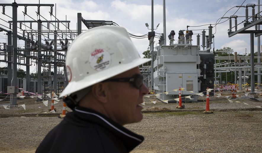In this Wednesday, May 20, 2015, file photo, Christian Vittorio, an AEP transmission field coordinator, gives a tour of an AEP electrical transmission substation in Westerville, Ohio. (AP Photo/John Minchillo) ** FILE **