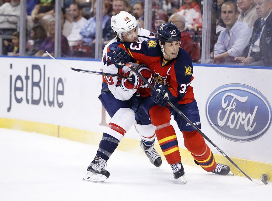 Florida Panthers defenseman Willie Mitchell (33) and Washington Capitals right wing Tom Wilson (43) battle for the puck during the first period of an NHL hockey game, Thursday, Dec. 10, 2015, in Sunrise, Fla. (AP Photo/Wilfredo Lee)