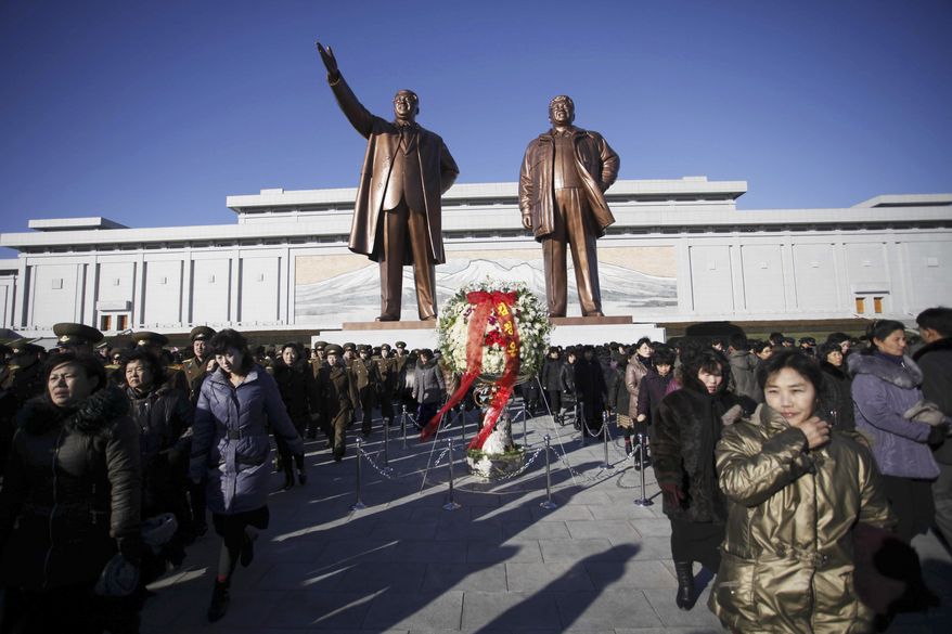 North Koreans bring floral tributes to Mansu Hill, where bronze statues of their late leaders Kim Jong Il and his father Kim Il Sung, stand, Thursday, Dec. 17, 2015, in Pyongyang, North Korea. Thousands visited the site to mark the fourth anniversary of Kim Jong Il's death. (AP Photo/Jon Chol Jin)
