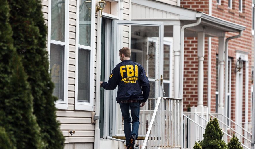 An FBI Joint Terrorism Task Force member enters a home in Harrisburg, Pa., Tuesday afternoon. Dec. 17, 2015, where Jalil Ibn Ameer Aziz, 19, was arrested on charges he attempted to provide support to the Islamic State group. Authorities say Aziz used Twitter to advocate violence against U.S. citizens and military members and to disseminate Islamic State propaganda. Federal prosecutors say a backpack in Aziz&#39;s closet contained five loaded high-capacity magazines, a modified kitchen knife, a thumb drive, medication and a balaclava, leading them to suspect he may have been plotting an attack.(James Robinson, /PennLive.com via AP)
