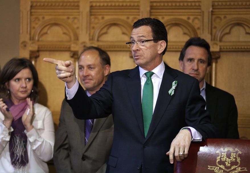 FILE - In this April 4, 2013, file photo, Connecticut Gov. Dannel P. Malloy, second from right, gestures gestures at the conclusion of a legislation signing ceremony as parents of two Sandy Hook shooting victims look on, at the Capitol in Hartford, Conn. Malloy proposed using an executive order to ban gun sales to people on federal no-fly lists. On Tuesday, Dec. 15, 2015, he said he was working with the White House and Justice Department for Connecticut officials to be able to use the watch lists directly, rather than relying on a check conducted through the NCIC process. (AP Photo/Steven Senne, File)