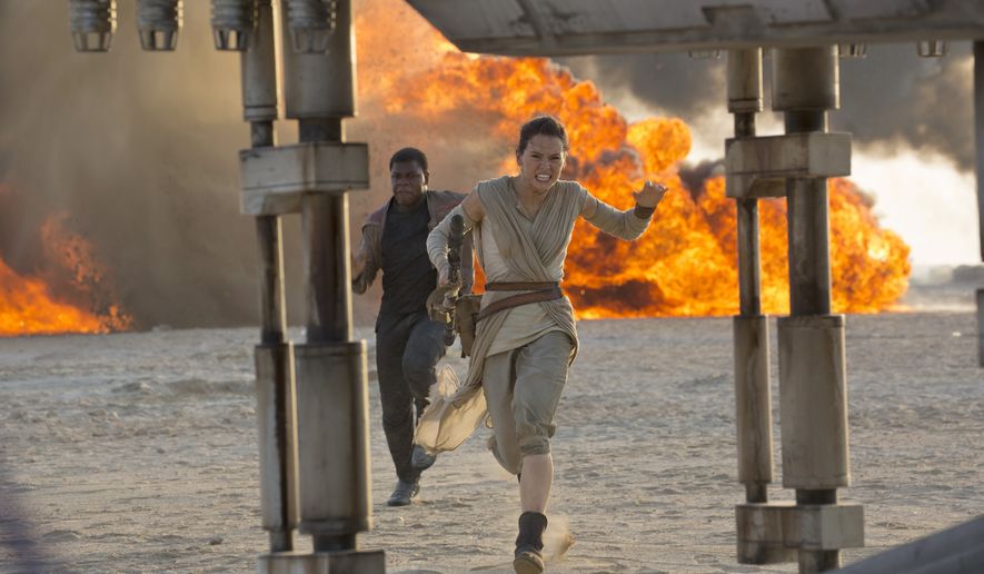 This photo provided by Disney/Lucasfilm shows Daisy Ridley, right, as Rey, and John Boyega as Finn, in a scene from the film, "Star Wars: The Force Awakens," directed by J.J. Abrams. The movie opens in U.S. theaters on Friday, Dec. 18, 2015. (David James/Disney/Lucasfilm via AP)