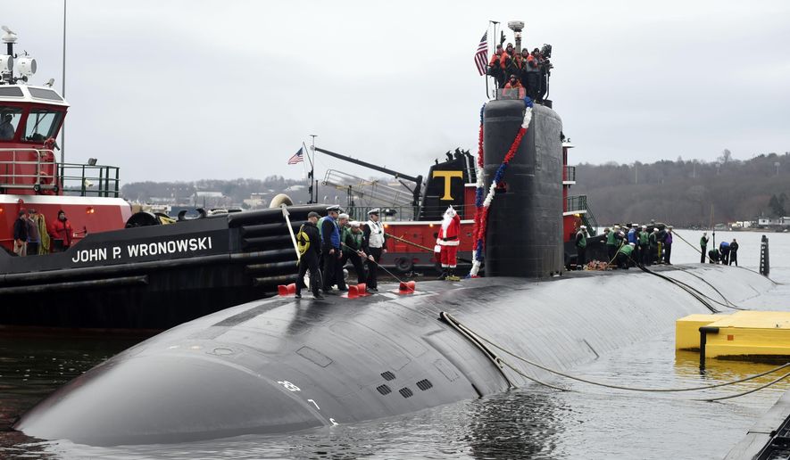 Santa, in the person of Petty Officer 1st class Wesley Anthony, waves from the deck as the U.S. Navy attack submarine USS Hartford returns to the U.S. Navy Submarine Base in Groton, Conn., Friday, Dec.18, 2015, following a six-month deployment to the European Command Areas of Responsibility. Hartford, with a crew of around 130 officers and enlisted personnel, made port calls in Faslane, Scotland and Rota, Spain during the deployment. (Sean D. Elliot/The Day via AP)