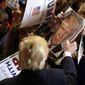 Republican presidential candidate Donald Trump signs autographs during a campaign rally at the Veterans Memorial Building, Saturday, Dec. 19, 2015, in Cedar Rapids, Iowa. (AP Photo/Charlie Neibergall)