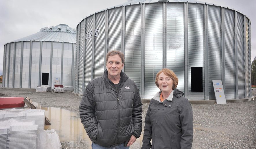 ADVANCE FOR SUNDAY, DEC. 20 AND THEREAFTER - Skagit Valley Malting founder Wayne Carpenter and Skagit Port executive director Patsy Martin stand ouside two large silos under construction that are part of the malting company's expansion at the Port of Skagit County in Burlington, Wash., Thursday, Dec 10, 2015. Originally conceived in collaboration with the Port of Skagit to increase the value of local grain, Skagit Valley Malting is malting and germinating grains no one else can. (Scott Terrell/Skagit Valley Herald via AP)