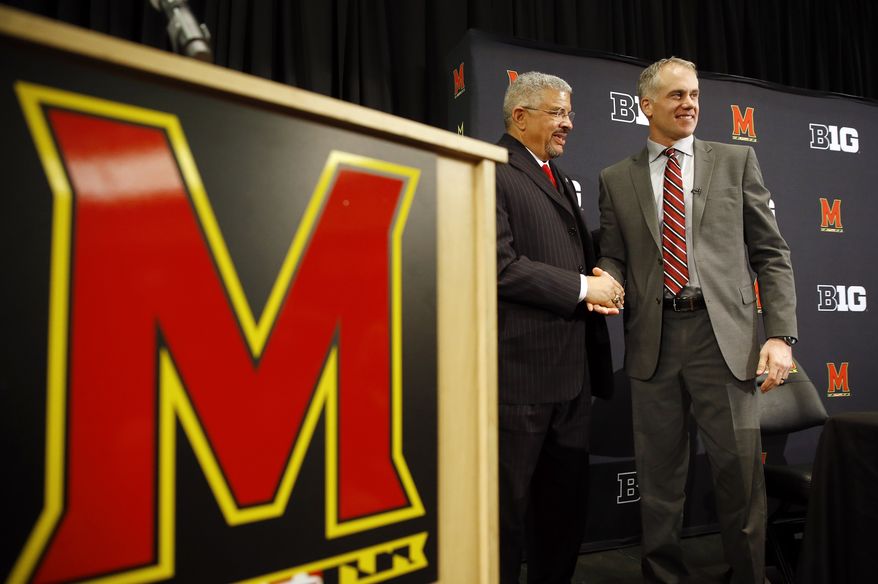 D.J. Durkin, right, poses for photographers alongside Maryland athletic director Kevin Anderson after being introduced as Maryland's new head football coach, Thursday, Dec. 3, 2015, in College Park, Md. Durkin comes from the University of Michigan, where he was the defensive coordinator and linebackers coach. (AP Photo/Patrick Semansky)